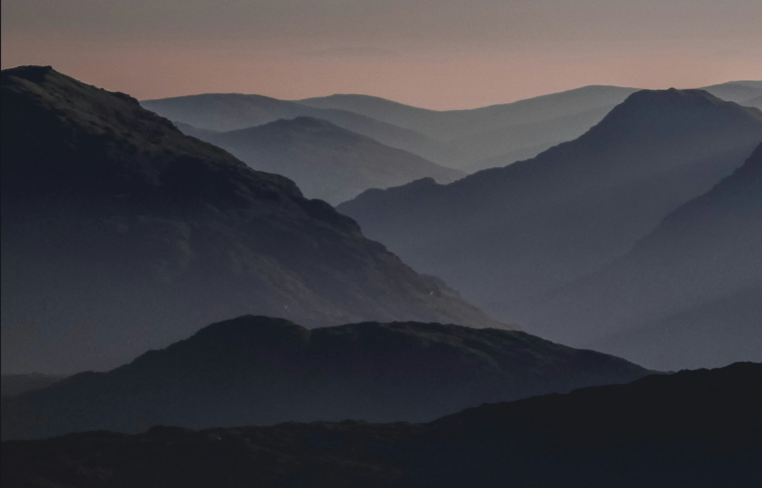 A photo of mountains against a dusky sky